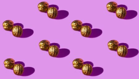 Seamless pattern with golden walnuts on pink background.の写真素材