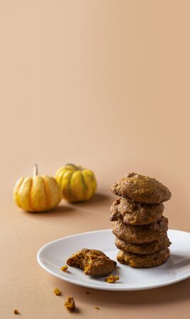 Homemade baked Healthy Pumpkin cookies stack on a white plate. Beige background, free Copy space.の写真素材