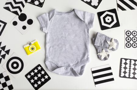 Composition with baby accessories on white background. Unisex neutral theme with baby shower or Newborn nursery concept with baby clothes, toys, Vision Development contrast cards. flat lay and top view.の写真素材