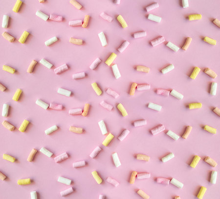 Pastel colored marshmallow candies pattern on a pink backgroundの写真素材