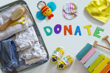 Baby Unisex neutral clothing and donation accessories on white background. Flat layの写真素材