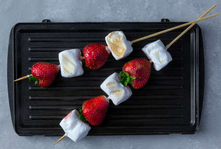 Gourmet Grilled Strawberry and Marshmallow on Stick on wooden skewers on grey background.の写真素材