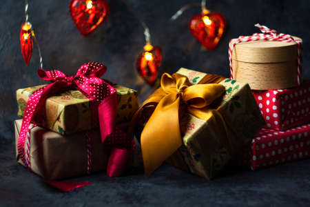 Christmas presents in red and natural colored paper on a dark backgroundの写真素材