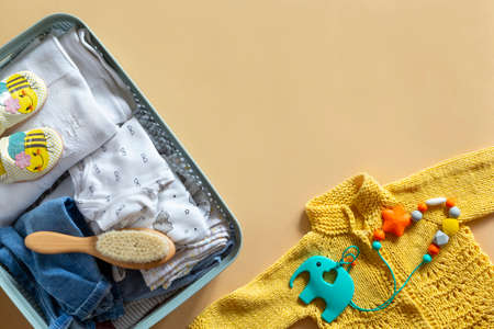 Donation box with Baby Unisex neutral clothing and donation accessories on beige background. Flat lay and copy spaceの写真素材