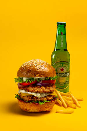 UKRAINE, KIEV - AUGUST 24, 2021: Big doubleburger with chicken cutlet, fries and Heineken beerのeditorial素材
