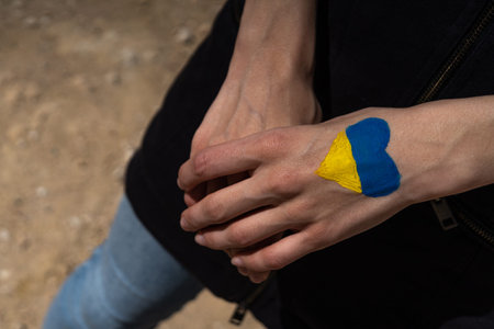 female hands painted in Ukraine flag colors in heart shapeの写真素材