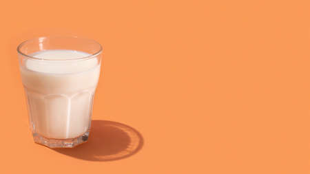 Milk in glass on beige backgroundの写真素材
