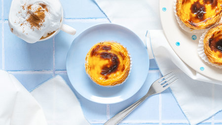 Portuguese dessert Pastel de nata with coffee on blue tile