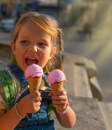 Cute little girl with two ice creams outside.