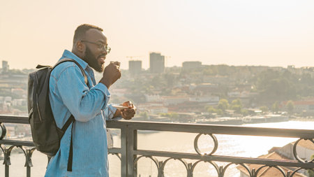 Traveller man drinking coffee on the Oporto bridgeの写真素材