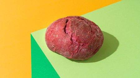Beetroot purple bun on minimal green background.の写真素材