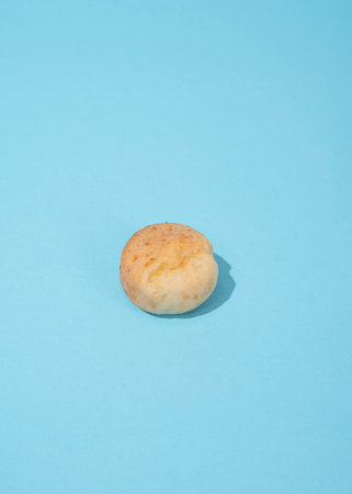 one fresh cheese bun on the blue backgroundの写真素材