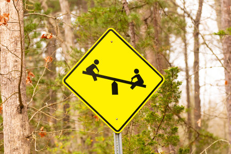 Warning, children at play on a seesaw rideの写真素材