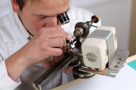 Watchmaker in his workshop repairing a wrist watch. Intentional shallow depth of fieldの写真素材