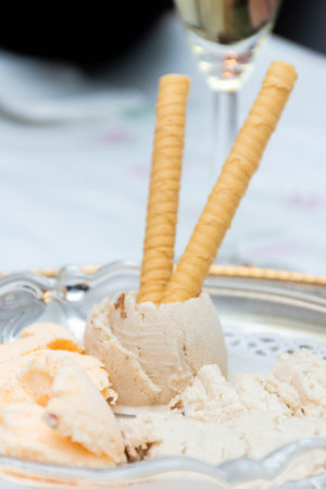 Vertical macro view of natural vanilla ice cream and stratachella with wafers Glass of champagne with a blurred backgroundの写真素材