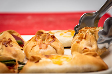 Horizontal macro view of canapÃ©s and sachets with vegetables and ham and a few waiter's tongs. New concept of Mediterranean cuisine, selected focus.の写真素材