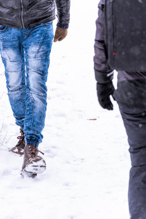 Selected focus. Concept of people walking in the snow. Crossing of people while doing sport in winter. Vertical image with people in the snow doing sportの写真素材