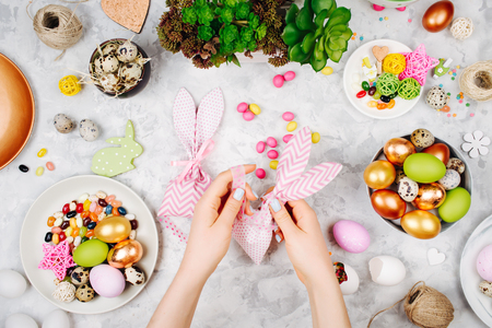Woman wraps treats in fabric bunny gift bags. Easter concept.の写真素材
