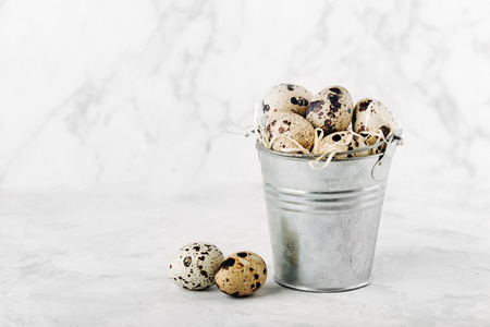 Bucket with  quail  eggs on a marble background.の写真素材