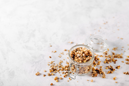 Homemade granola with nuts and seeds in glass jar for healthy breakfast with copy spaceの写真素材