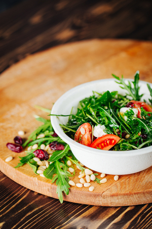 Healthy Salad with arugula, pine nuts, cranberries, tomatoes, and feta. Copy spaceの写真素材