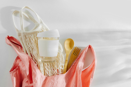 Pink cloth shopping bag with mesh market bag, bamboo cutlery  and  reusable coffee mug. Sustainable lifestyle. Zero waste, plastic free concept.の写真素材