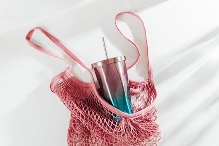 Mesh bag with reusable cup on white background. Eco friendly. Zero waste concept. No plastic.の写真素材