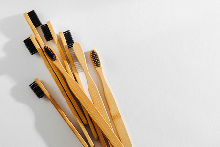 Wooden eco bamboo toothbrushes with black bristle on white background. Sustainable lifestyle. Zero waste concept.の写真素材
