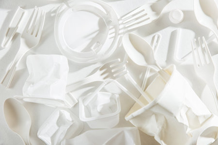 White single use plastic on  white background. Closeup. Concept of Recycling plastic and ecology....