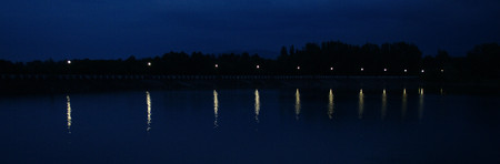Lighted dam in the evening  Lamplight reflected on a water surfaceの写真素材
