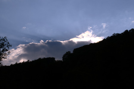 Sunset shining through the clouds over the horizon.の写真素材