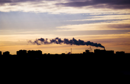 Sunset in the city (Ufa), smoke from the chimney silhouetted against the dusk sky.