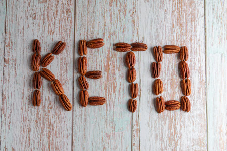 The inscription KETO DIET made from nuts, healthy fat and protein food, vegan, ketogenic diet, plant-based diet, close-up lies on a wooden backgroundの写真素材