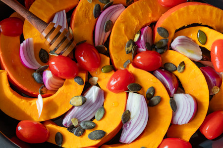 Baked hokkaido pumpkin in pieces on a baking trayの写真素材
