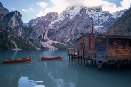 Several empty rowing boats on water surface of Lake Braies, Italy. Mountain scene with boat rental...