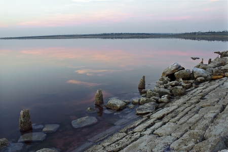 Sunrise over the lake, the stones in the foreground.の写真素材