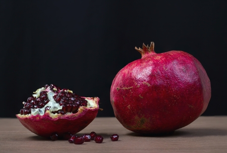 Whole and slice of ripe pomegranate on a black background.の写真素材