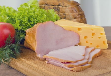 smoked meat and cheese on a wooden board.の写真素材