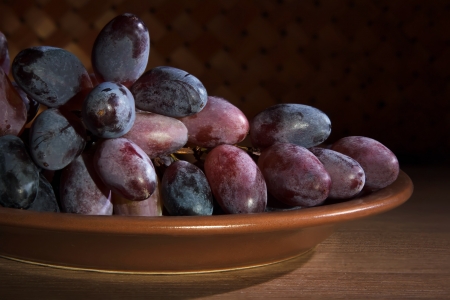 Bunches of ripe grapes on a ceramic plateの写真素材