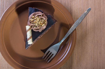 Piece of dark chocolate cake with chocolate frosting and walnuts.の写真素材