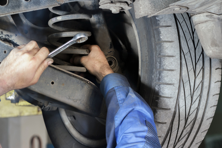 Hands mechanics to repair the suspension on the carの写真素材