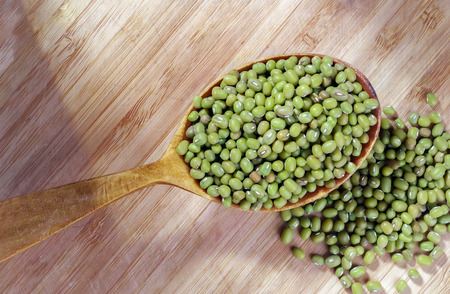 Green lentils in a spoon on a wooden backgroundの写真素材