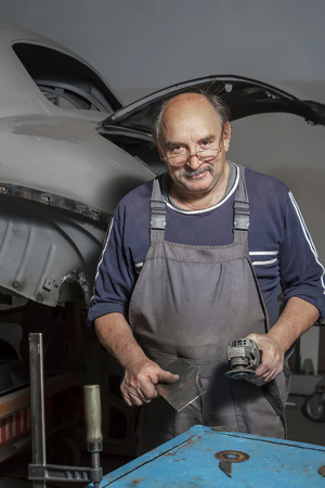 Portrait of a happy middle-aged worker in his workshop.の写真素材