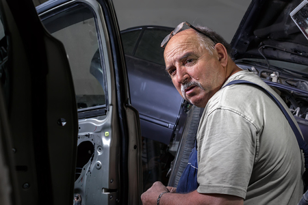 Portrait of a happy middle-aged worker in his workshop.の写真素材
