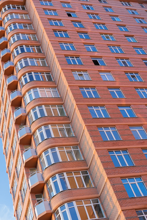 Beautiful facade of a new multi-storey residential building made of red brick.の写真素材