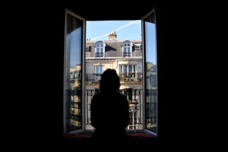 Woman penetrates into the beauty of Paris through the window.の写真素材