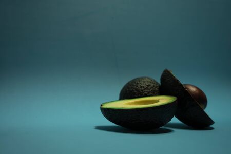 avocados presented on light blue backgroundの写真素材