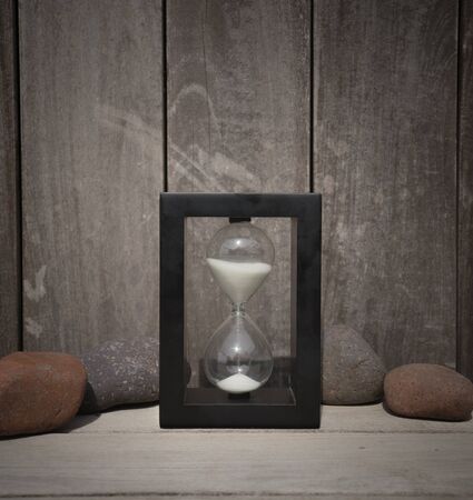 hourglass and stones on woodの写真素材