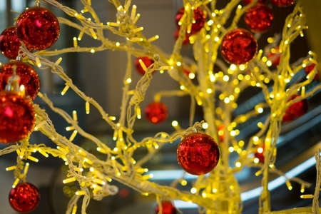 Red christmas balls hanging on the lighting treeの写真素材