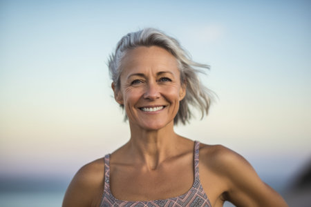 Portrait of smiling senior woman standing on beach at the day timeの素材